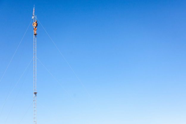 man wearing blue brief standing ladder